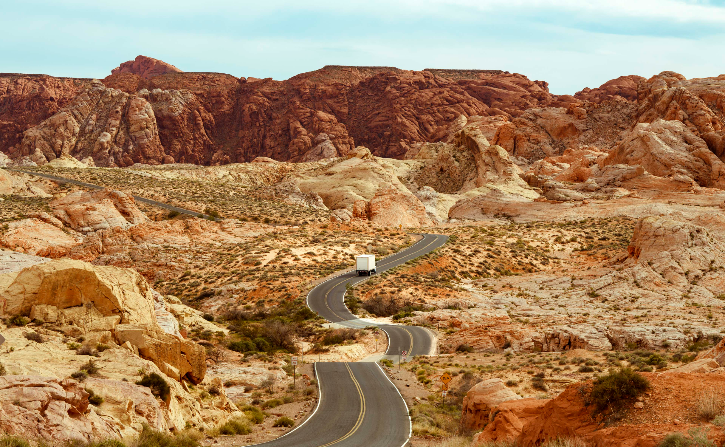 A truck on a windy road in the desert