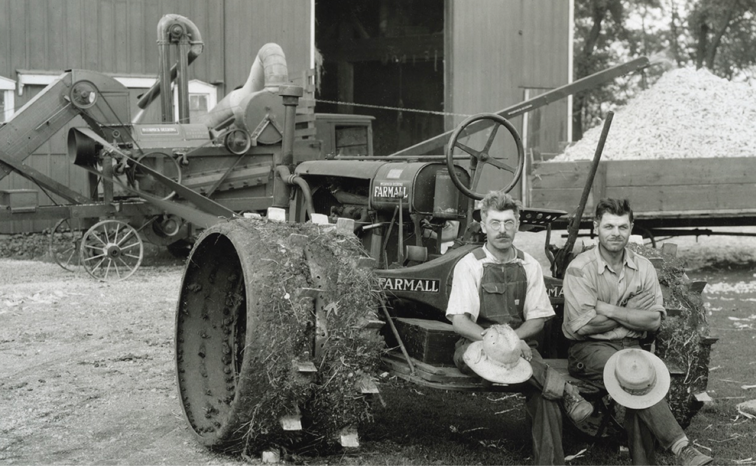 A tractor and 2 men sitting on top of it