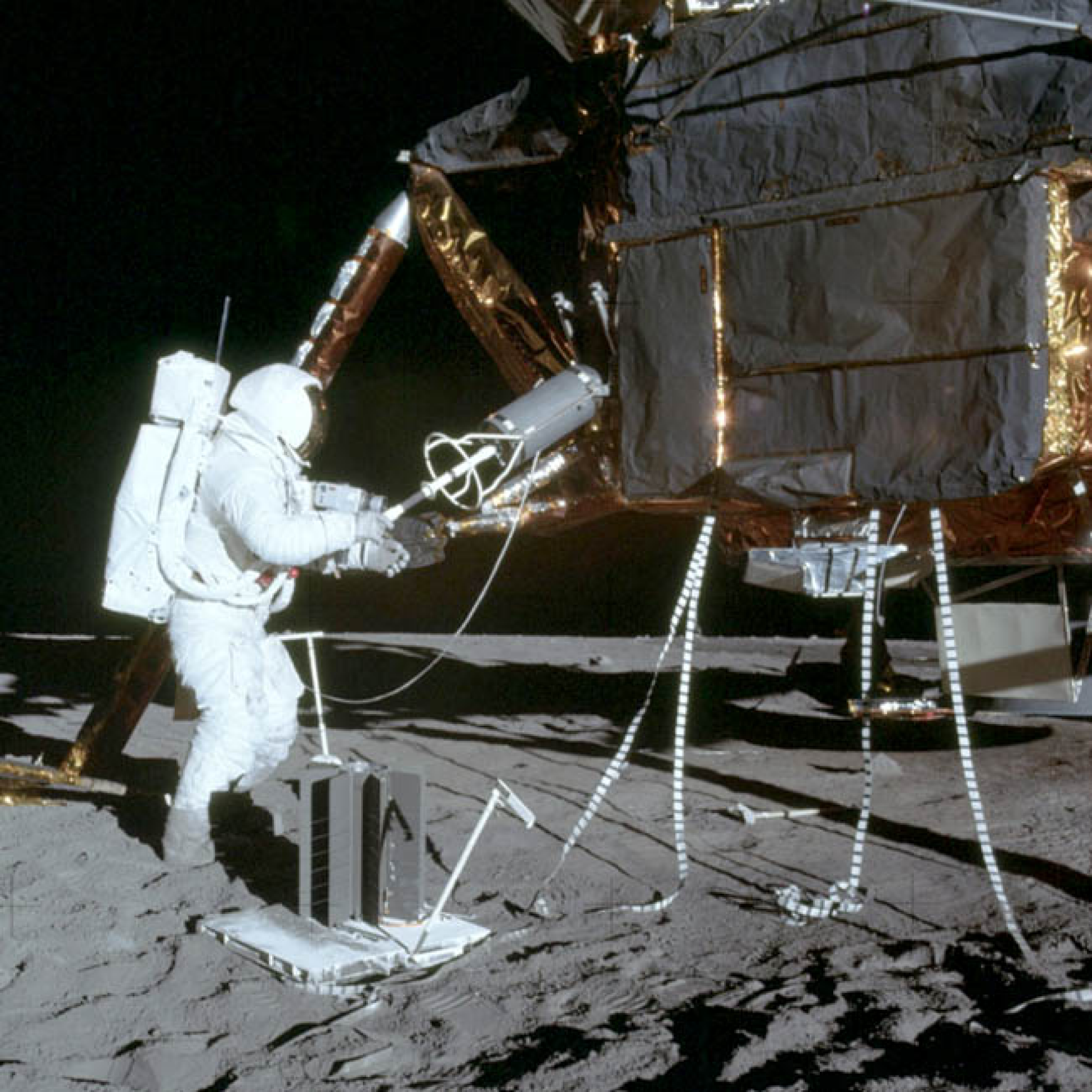 Image: Apollo 12 Astronaut Alan Bean unloads the RGT fuel element container, which was  constructed by International Harvester's Solar Division.