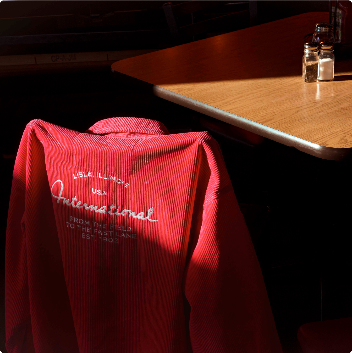 A international jacket hanging on a chair next to a table in a restaurant